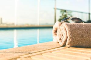 斯利马AX The Victoria Hotel的坐在泳池旁毛巾上的一双太阳镜
