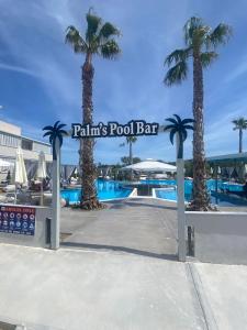 佩科霍里安娜酒店的棕榈树游泳池和池畔酒吧标志