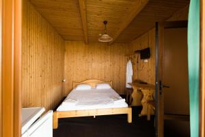 斯维季亚济ТУРБАЗА NESTER-HOUSE的一间小卧室,配有一张位于木制房间内的床