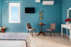 加拉塔斯Evi Boutique Rooms的一间卧室设有蓝色的墙壁、两把椅子和一张桌子