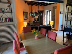 梅纳La Dolce Vita的用餐室配有木桌和粉红色椅子