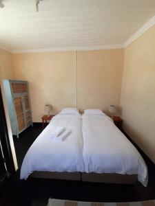 开普敦Cozy room in the Heart of Simon's Town的一间卧室配有一张带两个白色枕头的大床