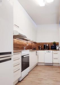 约恩苏Niinivaara apartment saunallinen ja ilmastoitu majoitus的白色的厨房配有白色家电和木墙
