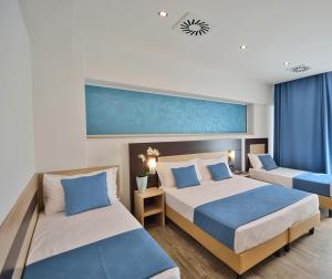 佛罗伦萨卢克索佛罗伦萨酒店的一间卧室配有两张带蓝白色枕头的床