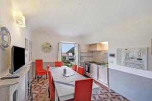 菲纳莱利古雷Trilocale Ginevra的厨房配有餐桌和红色椅子