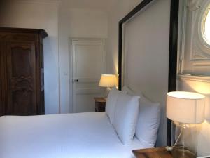 尼翁Suite Petite -Nice - SPA-JACUZZI - MASSAGE- SAUNA - 4 SAISONS - Piscine Chauffée Toute l'année - POOL VIEW- Heated Pool 800m city centre Nyons的一间卧室配有带白色床单和枕头的床。