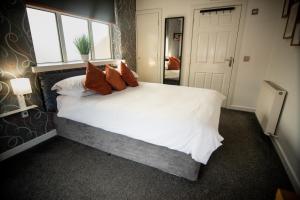 欧文The Dwelling Place的卧室配有带红色枕头的大型白色床