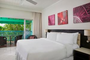 圣詹姆斯Crystal Cove by Elegant Hotels - All-Inclusive的一间带白色床的卧室和一个阳台
