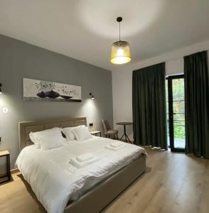 地拉那Vila Jasmine的卧室配有白色大床和绿色窗帘