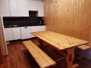 AustertanaVARANGER KITE CAMP的厨房配有木制桌子和白色橱柜