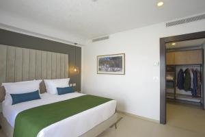 突尼斯MAIA HOTEL SUITES的一间卧室配有一张大床和一个衣柜