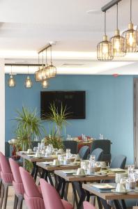 突尼斯MAIA HOTEL SUITES的用餐室配有木桌和粉红色椅子