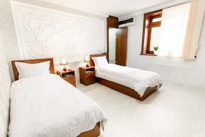撒马尔罕Old Town Samarkand的酒店客房设有两张床和窗户。