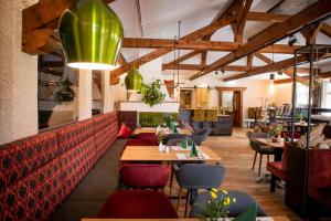 圣沃尔夫冈博格斯坦酒店的一间带木桌和椅子以及绿色吊灯的餐厅