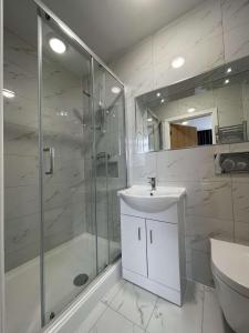 伦敦Best Western Northfields Ealing Hotel的带淋浴、盥洗盆和卫生间的浴室
