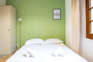 普瓦捷Le Mélusine , à 50m de la gare de Poitiers的绿色墙壁的房间里一张白色的床