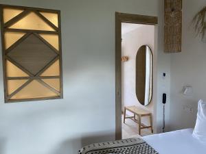 圣马迪拉莫Hôtel du Pont Blanc的卧室配有一张床,墙上设有镜子