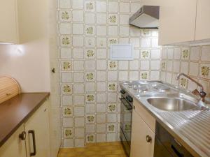 克莱恩 蒙塔纳Apartment Les Faverges-4 by Interhome的一间带水槽和瓷砖墙的厨房