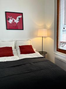 巴黎MaisonZen的一间卧室配有一张带红色枕头的床和一扇窗户