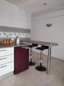 哈曼苏斯Studio à Hammam Sousse的厨房配有柜台和2个酒吧凳