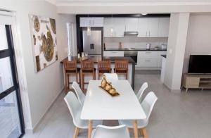 开普敦MLMK Property 17的厨房以及带白色桌椅的用餐室。