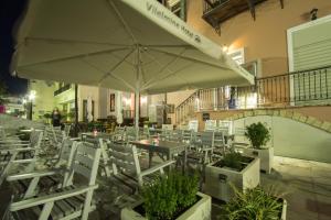 干尼亚维勒米内酒店的一间带桌椅和遮阳伞的餐厅