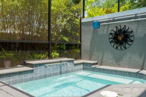 基西米Fun Vacation Home Close to Disney and Outlets at Le Reve Resort 4449的墙上有一个钟表的游泳池