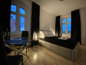 托伦VIP Rooms Apartment的卧室配有床、桌子和窗户。