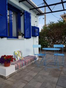 斯卡拉Casa Ble - Izla Homes的天井上配有长凳、两把椅子和一张桌子