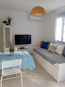 斯卡拉Casa Ble - Izla Homes的一间卧室配有一张床、一张桌子和一台电视。