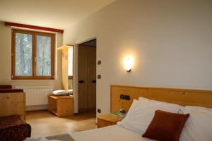 卡瓦雷诺hotel Parco Pineta的卧室配有一张床,墙上有灯