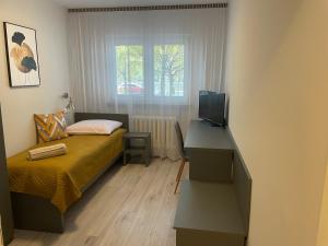 华沙O-ES-HA旅馆的一间卧室配有一张床和一张书桌及电视