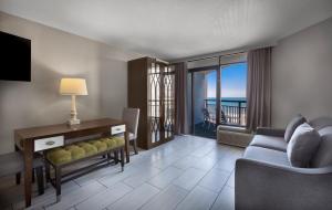 默特尔比奇蓝色酒店的带沙发和书桌的客厅,享有美景。
