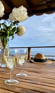 圣拉斐尔Mobil Home superbe Vue Mer St Raphaël的两杯白葡萄酒和一顶帽子在桌子上