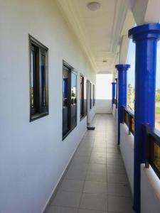 科托努Villa Cocotiers A11的建筑里带蓝色柱子和窗户的走廊