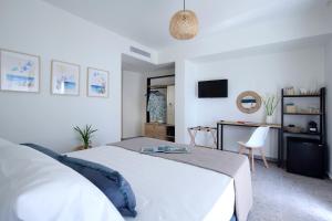 利吉亚ALMYRA seafront residence的卧室配有白色的床和书桌