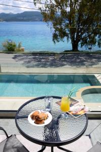 利吉亚ALMYRA seafront residence的一张桌子,上面放着一盘食物和一杯橙汁