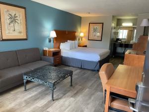 德斯坦德斯廷乡村酒店的酒店客房配有床、沙发和桌子。