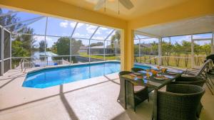 珊瑚角!NEW! Villa Sunshine private Pool的一个带桌子和游泳池的庭院