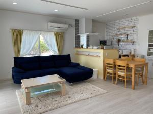 土庄町Holiday Villa 旅生的客厅配有蓝色的沙发和桌子