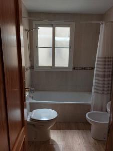 拉斯加比亚斯Home&Holidays Las Gabias, Granada的一间带卫生间和浴缸的浴室以及窗户。