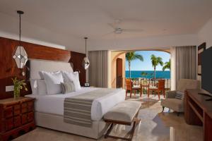 卡波圣卢卡斯Zoetry Casa del Mar Los Cabos的一间卧室配有一张床,另一间用餐室享有海景