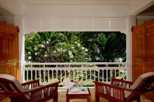 华欣盛泰澜华欣海滩别墅及度假村的客房设有带椅子和桌子的大窗户。