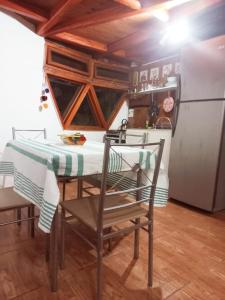 圣佩德罗·德·阿塔卡马Hermoso Domo ECOconstruido的厨房配有桌椅和冰箱