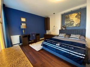 格丁尼亚特兰萨兰提克公寓的一间卧室设有蓝色的墙壁和一张带枕头的床。