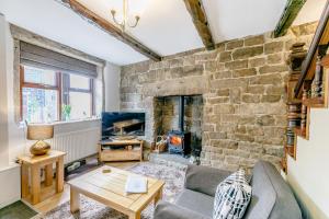 海伯敦桥Weavers Cottage的客厅设有带壁炉的石墙