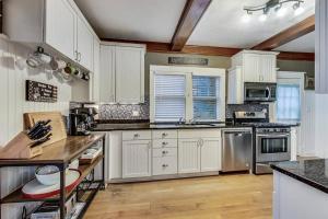 日内瓦湖Bay's Place Vacation Rental的厨房配有白色橱柜和不锈钢用具