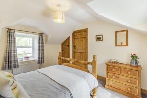 阿尼克Briar Cottage的一间卧室配有一张床、一个梳妆台和一扇窗户。