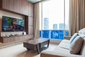 吉隆坡Soho Suites KLCC by GuestHouse的客厅配有沙发和带大窗户的电视。