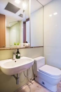 吉隆坡Soho Suites KLCC by GuestHouse的一间带水槽、卫生间和镜子的浴室